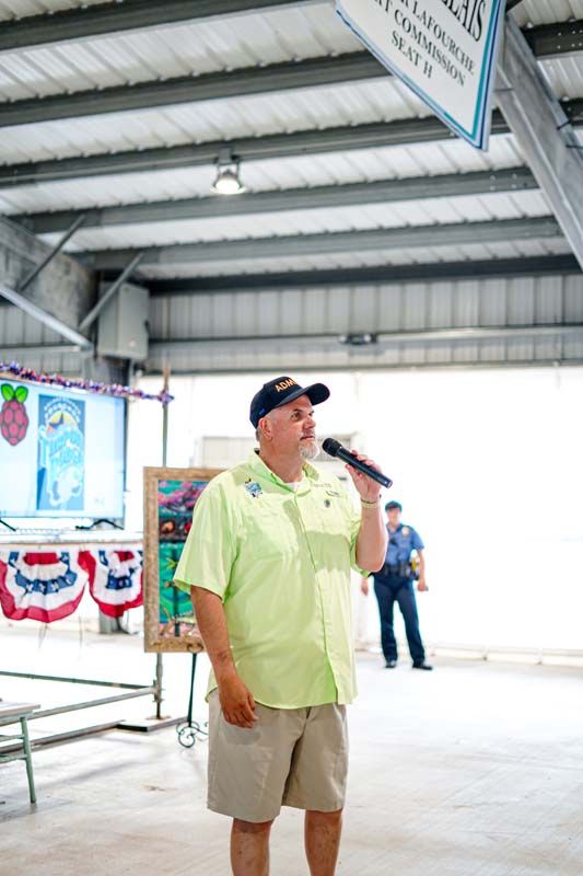 A man is standing in front of a microphone in a building.