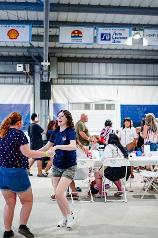 A group of people are dancing in a large room.