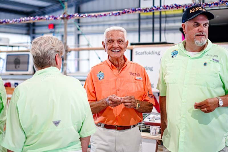Three men are standing next to each other in a room and smiling.