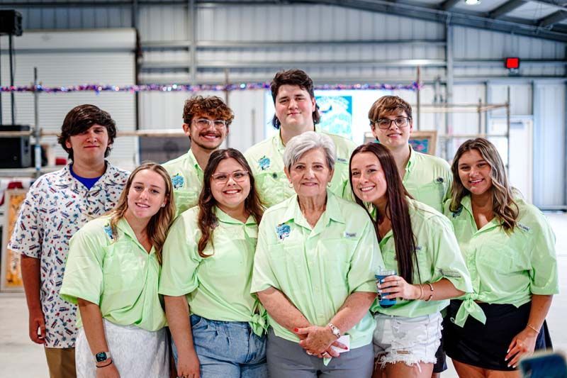 A group of people in green shirts are posing for a picture.