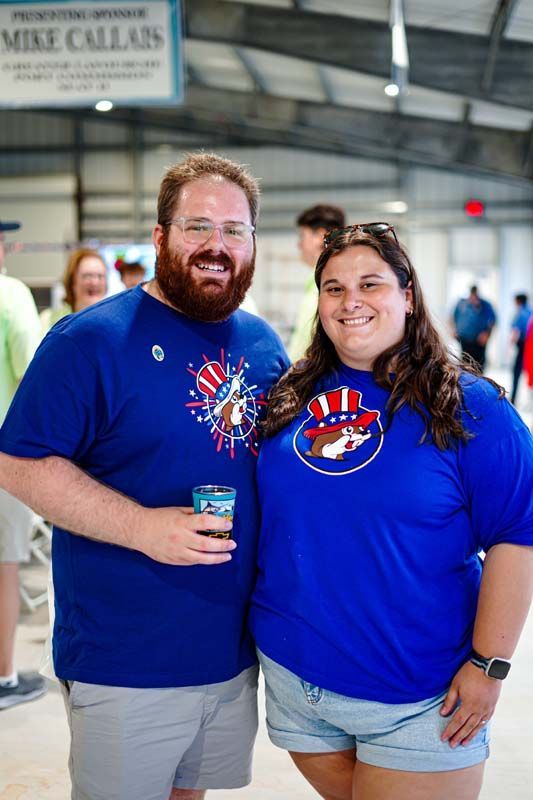 A man and a woman are posing for a picture while wearing blue shirts.