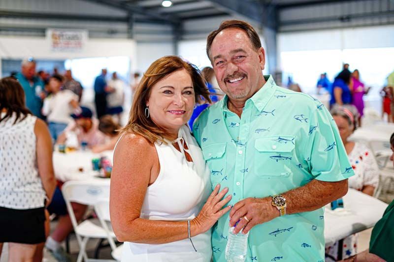 A man and a woman are posing for a picture at a party.