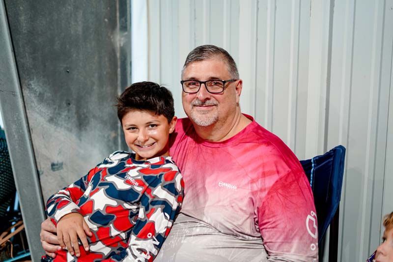 A man and a boy are sitting next to each other on a chair.