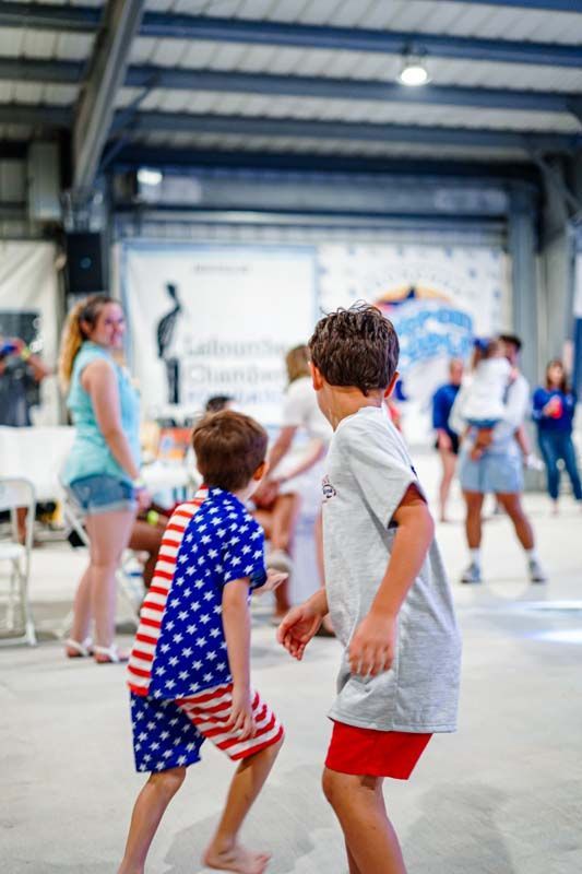 Two young boys are dancing together in a room.