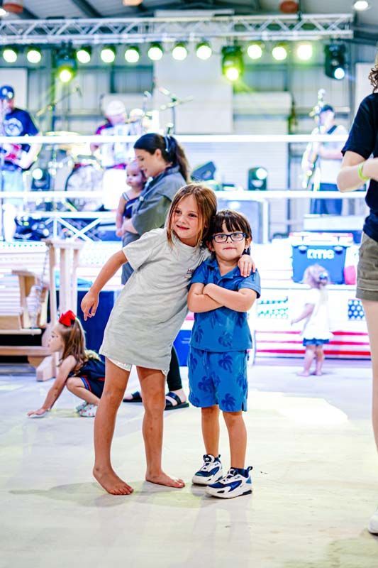 A boy and a girl are standing next to each other in a room.