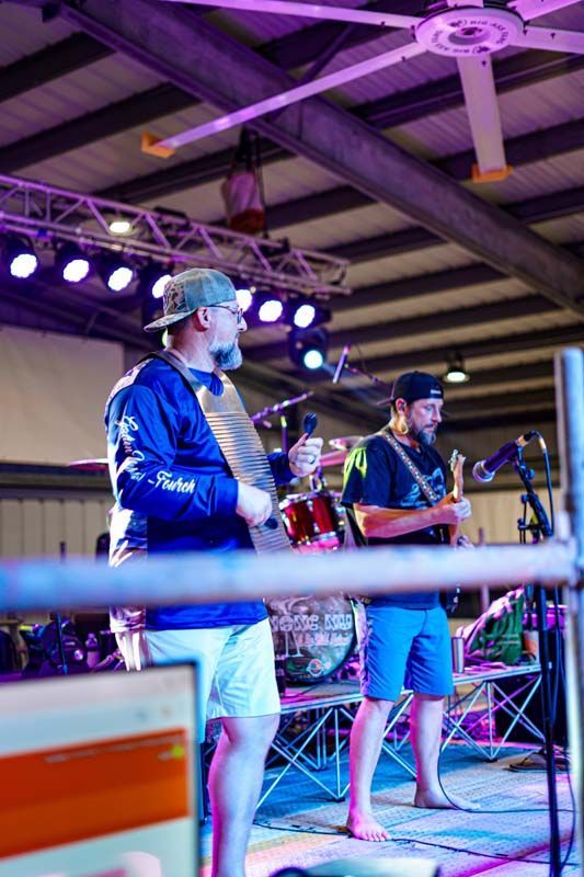 Two men are standing on a stage playing guitars.