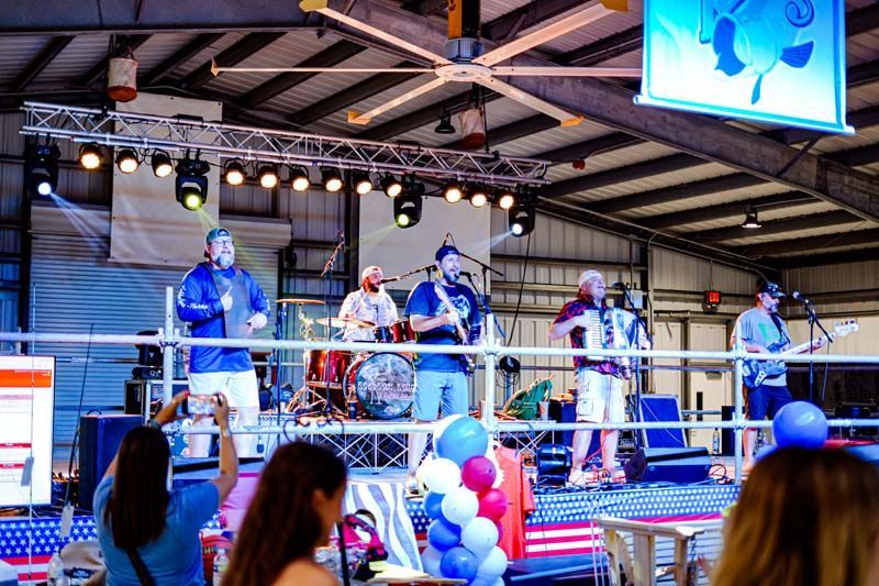 A group of people are standing on a stage playing instruments.