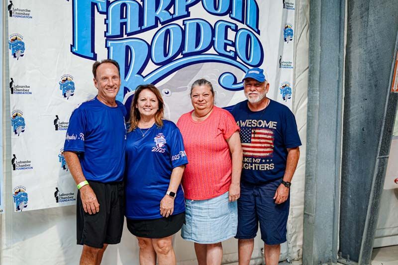 A group of people are posing for a picture in front of a rodeo sign.