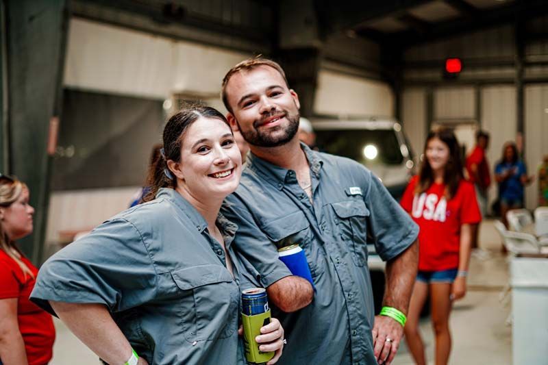 A man and a woman are posing for a picture in a warehouse.