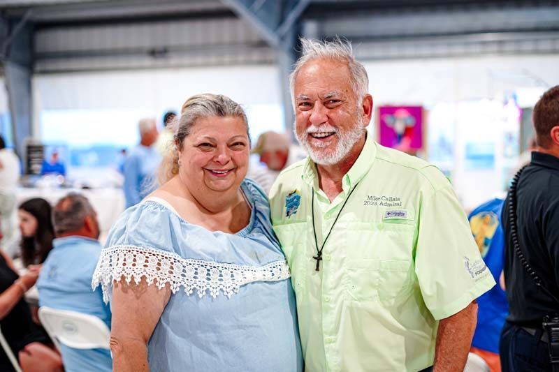 A man and a woman are posing for a picture at a party.