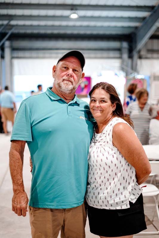 A man and a woman are standing next to each other in a room.