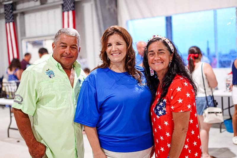 A man and two women are posing for a picture together.