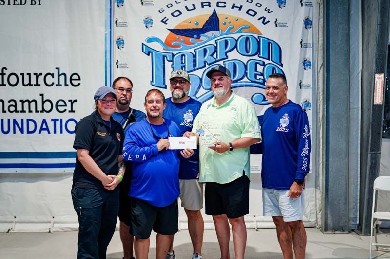 A group of men standing in front of a banner that says fourchon