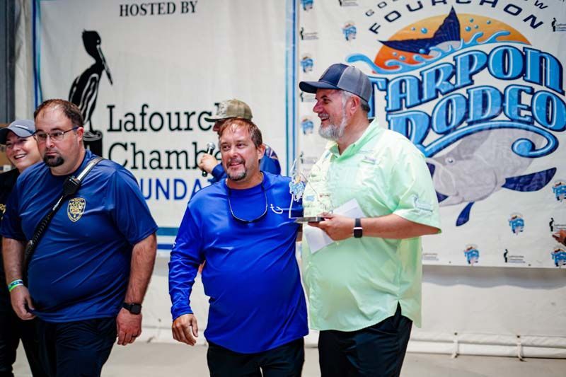 A group of men are standing in front of a sign that says lafourge chamb 's foundation.
