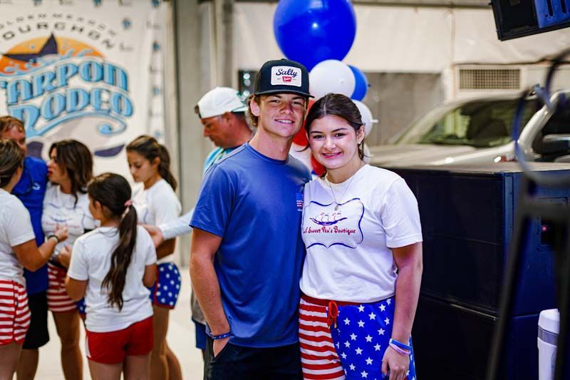 A man and a woman are posing for a picture in front of balloons.