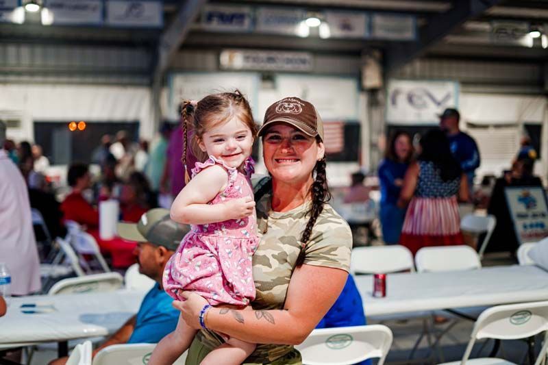 A woman is holding a little girl in her arms.