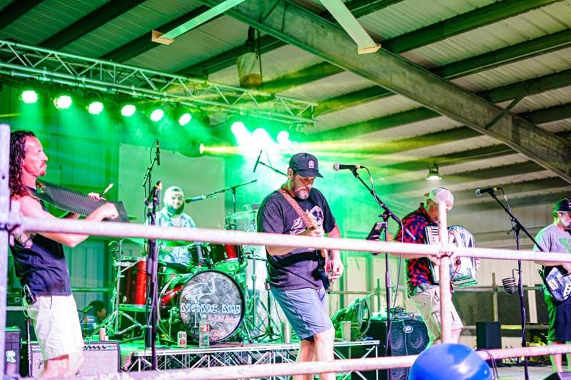 A group of people are standing on a stage playing instruments.