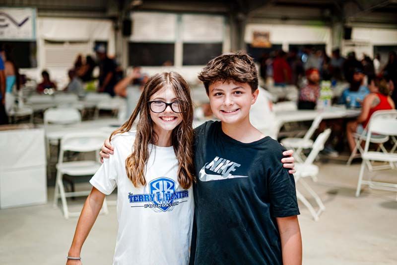 A boy and a girl are posing for a picture together.