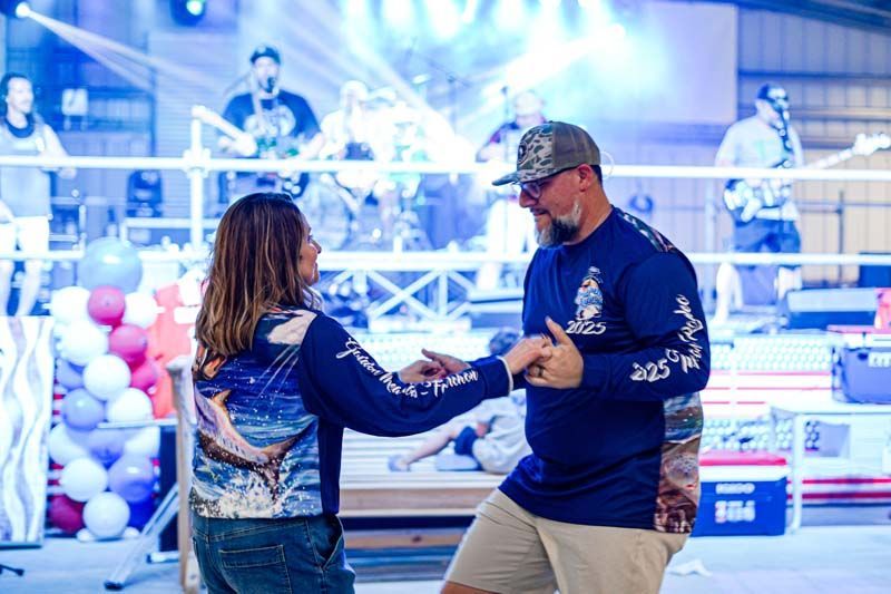 A man and a woman are dancing in front of a band.