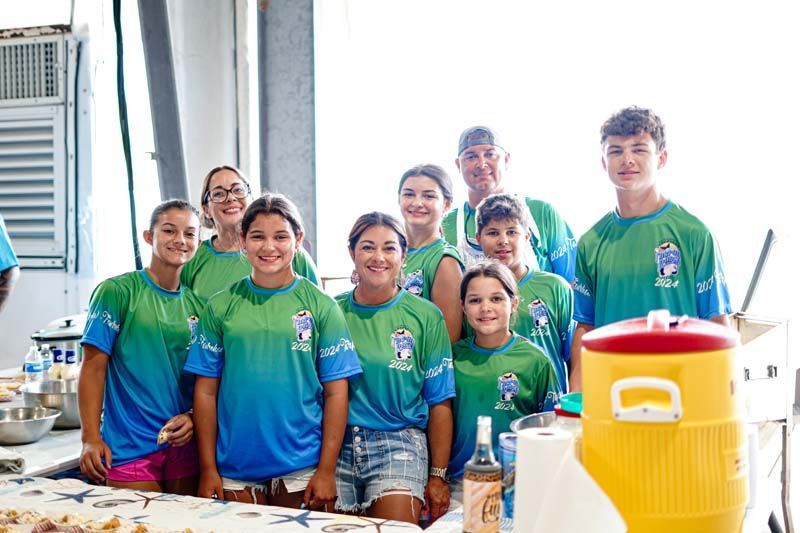 A group of young people wearing blue and green shirts are posing for a picture.