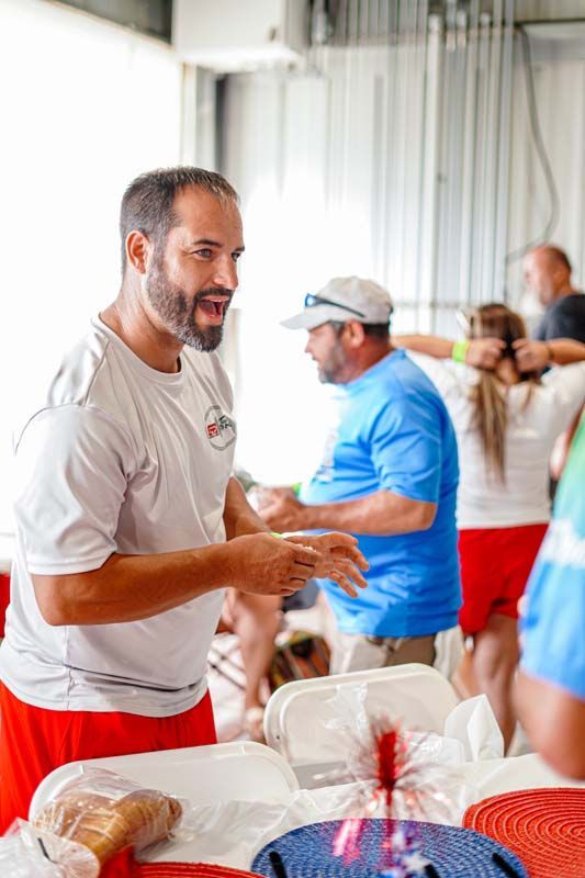 A man with a beard is standing in front of a table with food.