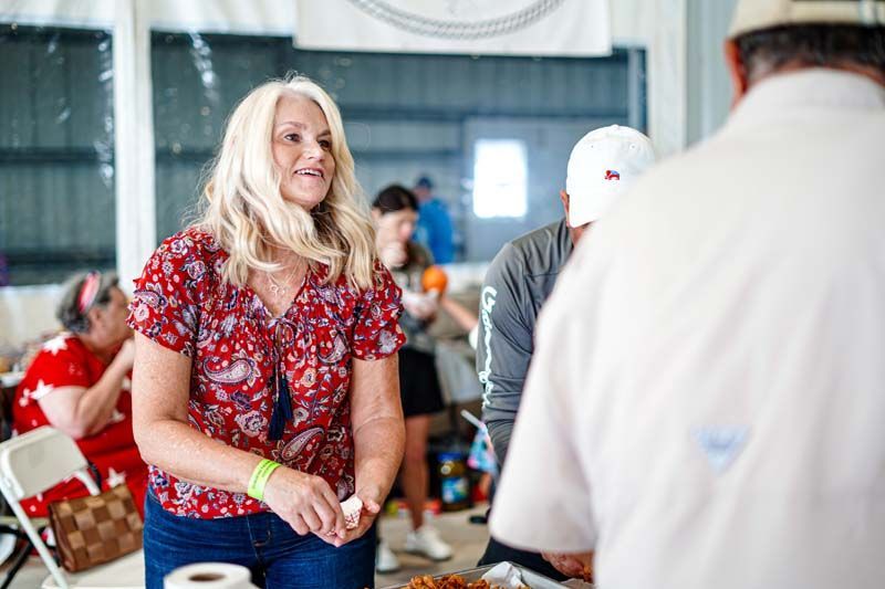 A woman is standing in a room talking to a man.
