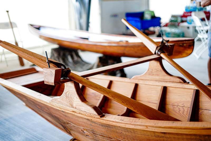 A wooden boat with oars is sitting on a table.