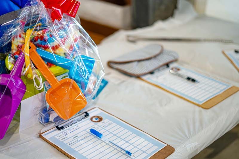 A table with a bag of candy and a clipboard with a pen on it.