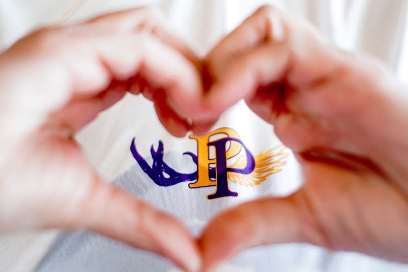 A person is making a heart shape with their hands