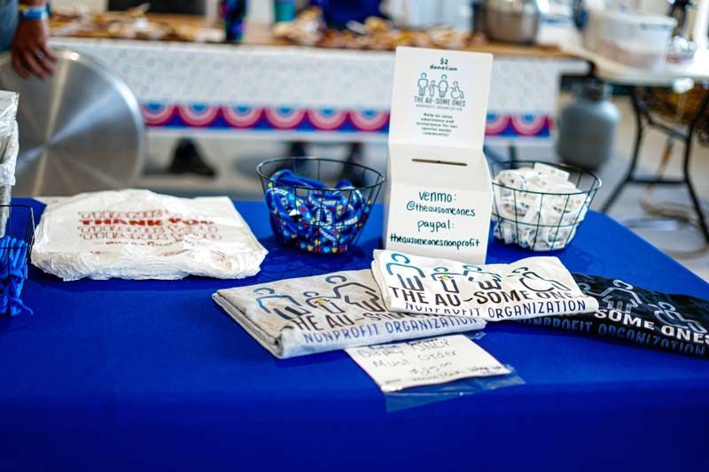 A table with a blue table cloth and a basket of candy on it.