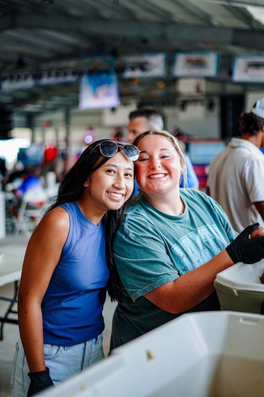 Two women are posing for a picture together in a room.