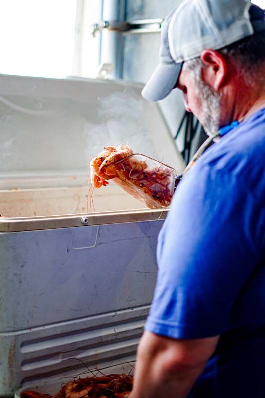 A man is taking a slice of pizza out of a freezer.