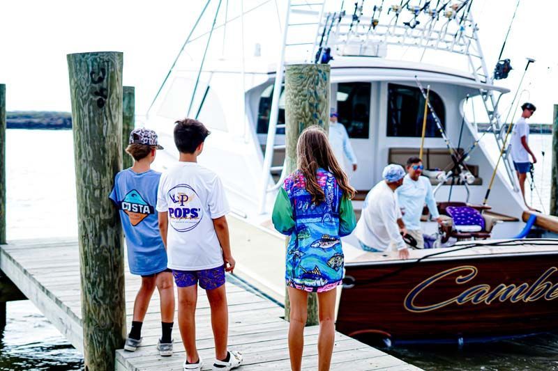 A group of people are standing on a dock next to a boat.