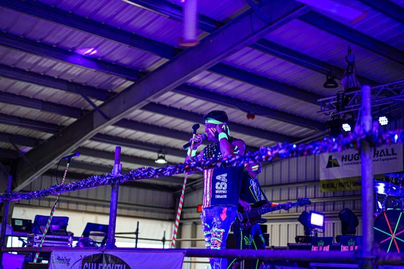 A person is standing in a boxing ring with purple lights.
