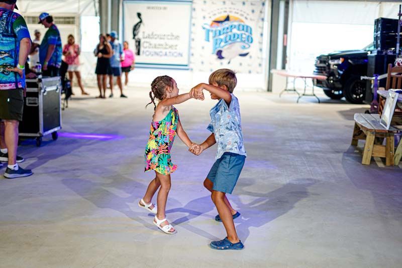 A boy and a girl are dancing together in a room.