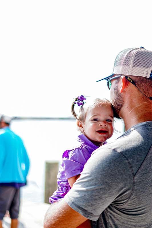 A man is holding a little girl in his arms.