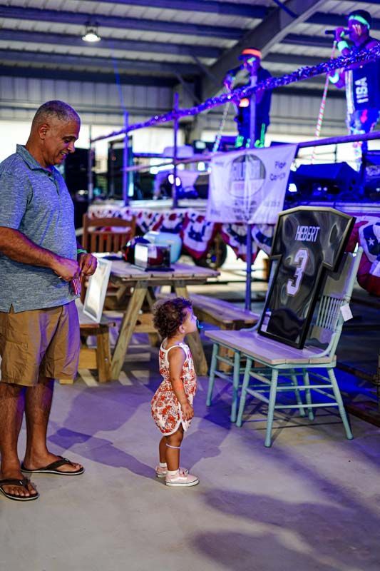 A man and a little girl are standing next to each other in a room.