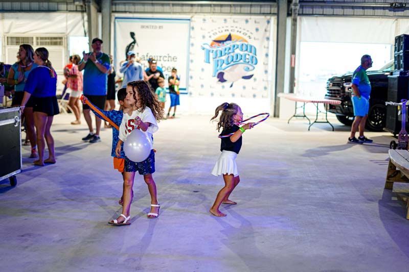 Two little girls are playing with balloons in a garage.