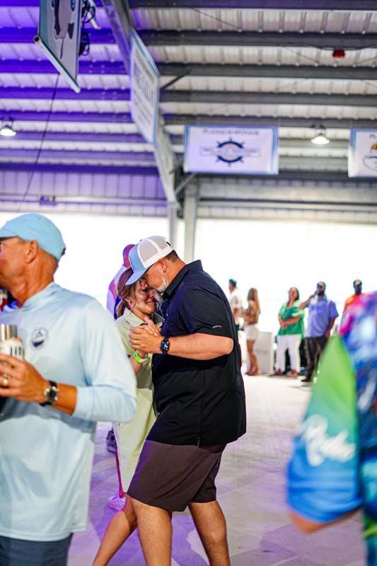 A group of people are standing in a room holding drinks.