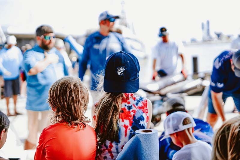 A group of people are sitting in front of a boat.