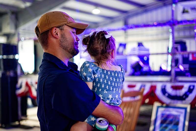 A man is holding a little girl in his arms.