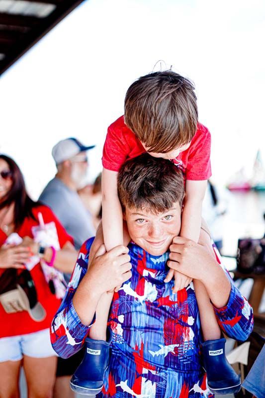 A boy is carrying another boy on his shoulders.