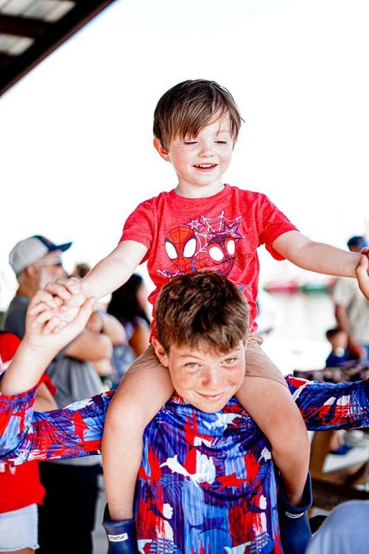 A little boy is sitting on a man 's shoulders.