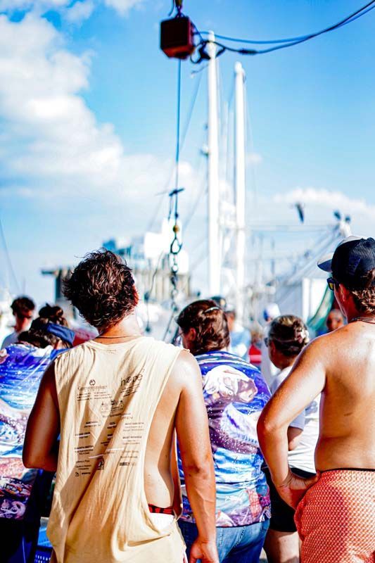 A group of people are standing in front of a boat.