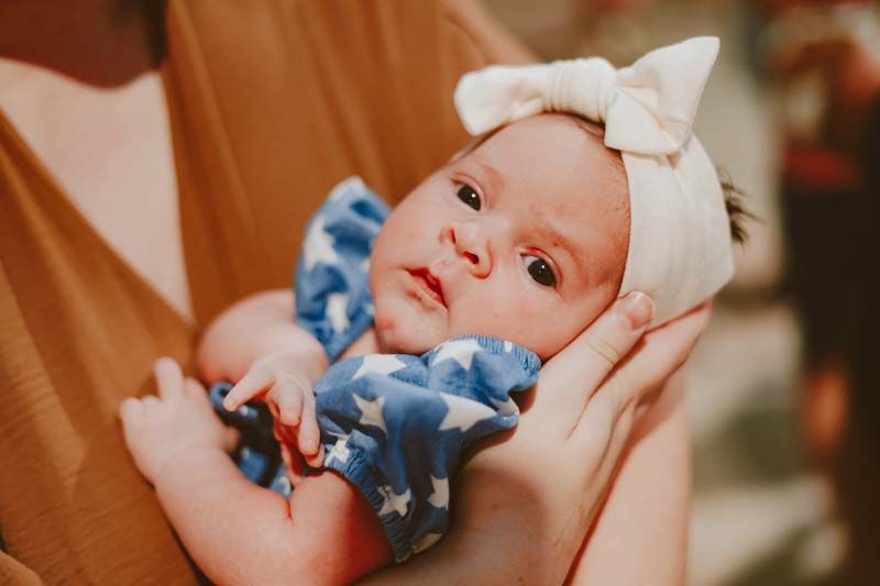 A woman is holding a newborn baby in her arms.