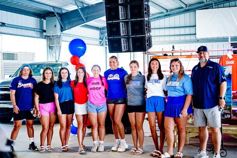 A group of people are posing for a picture in a garage.