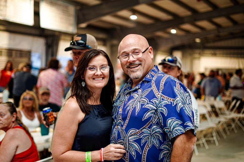A man and a woman are posing for a picture at a party.