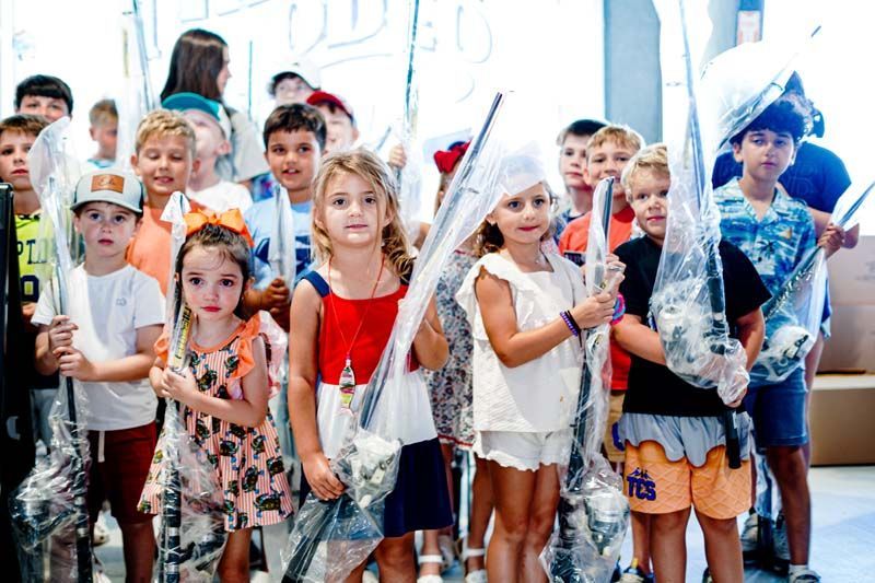 A group of children are standing next to each other holding balloons.