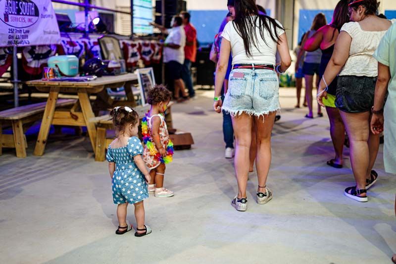 A group of people are standing around a picnic table.