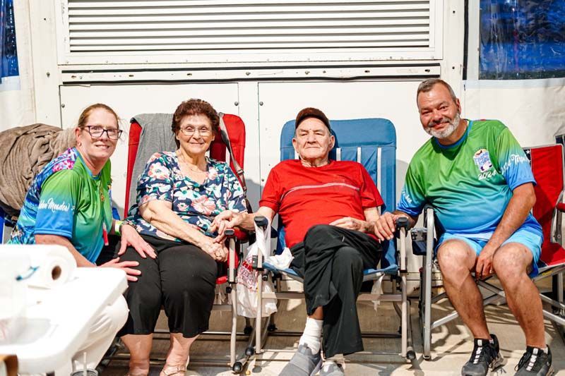 A group of people are sitting in chairs in front of a building.